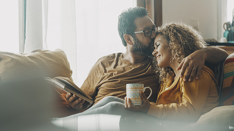 Couple of young adult man and woman enjoy time together sitting on the sofa in indoor leisure activity