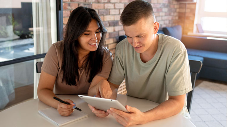 Couple-deciding-how-much-they-need-in-their-emergency-fund-while-looking-at-their-accounts-at-a-table-together.