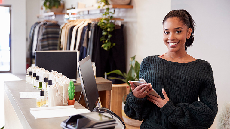 Female assistant smiling from the counter in clothing store
