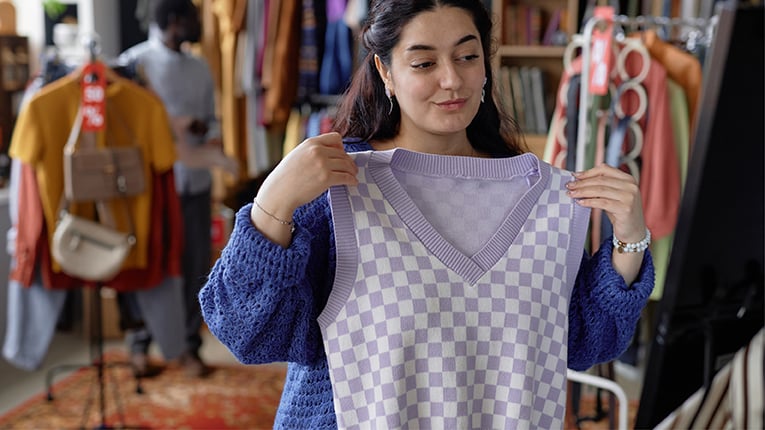 Happy Woman Trying Sweater Vest Shopping at Thrift Store