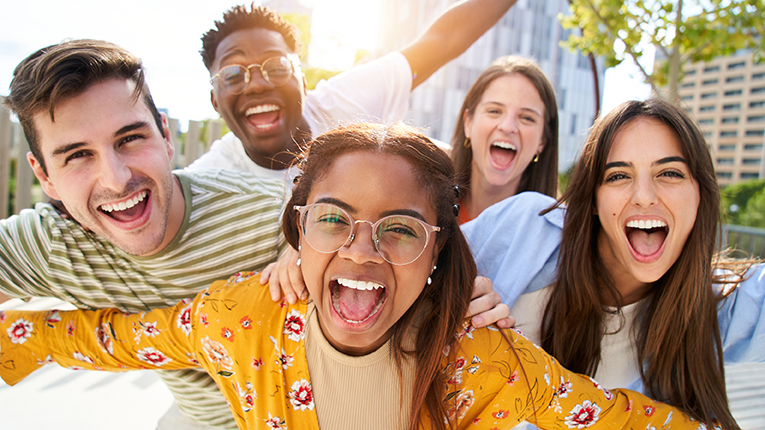 Happy, young diverse friends looking at camera smiling