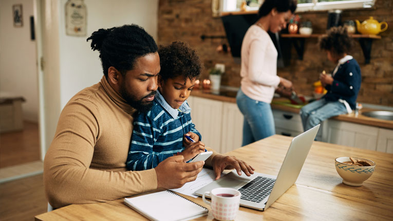 Husband-is-figuring-out-how-much-money-he-should-have-saved-by-now-at-the-kitchen-table-surrounded-by-family.