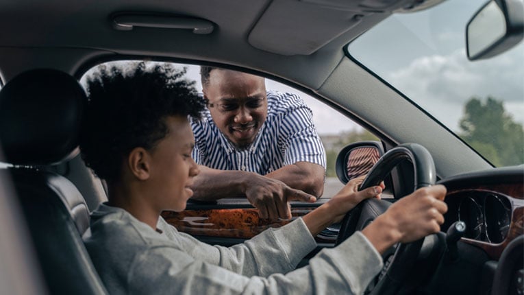 Son-in-driver-seat-of-car-is-a-first-time-car-buyer-getting-tips-from-his-dad.