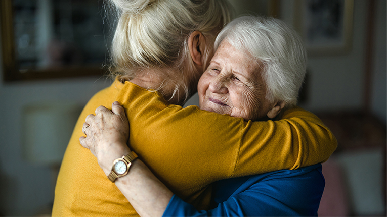 Woman hugging her elderly mother