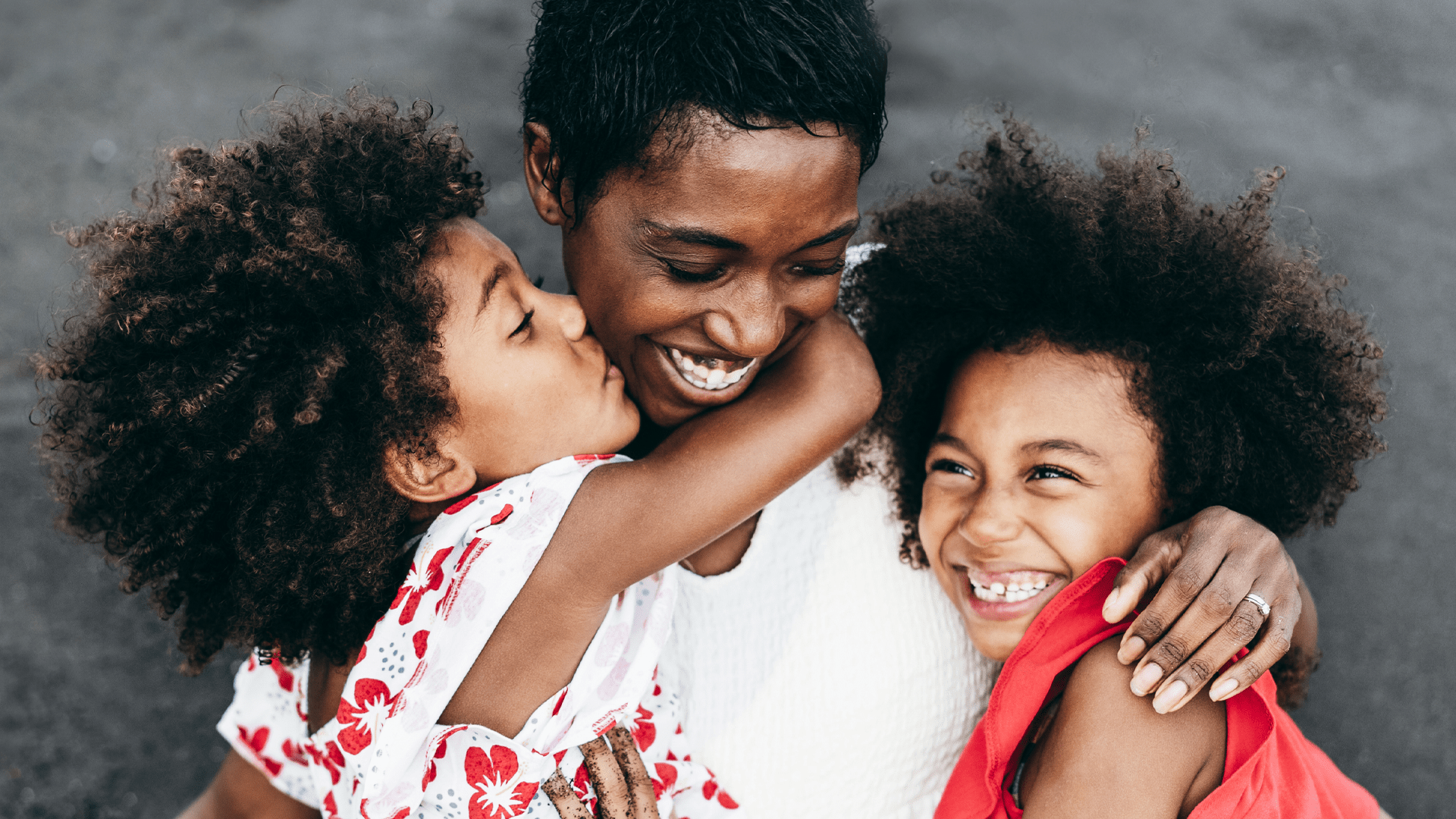 Mom hugging her daughters after feeling relief from a personal loan.