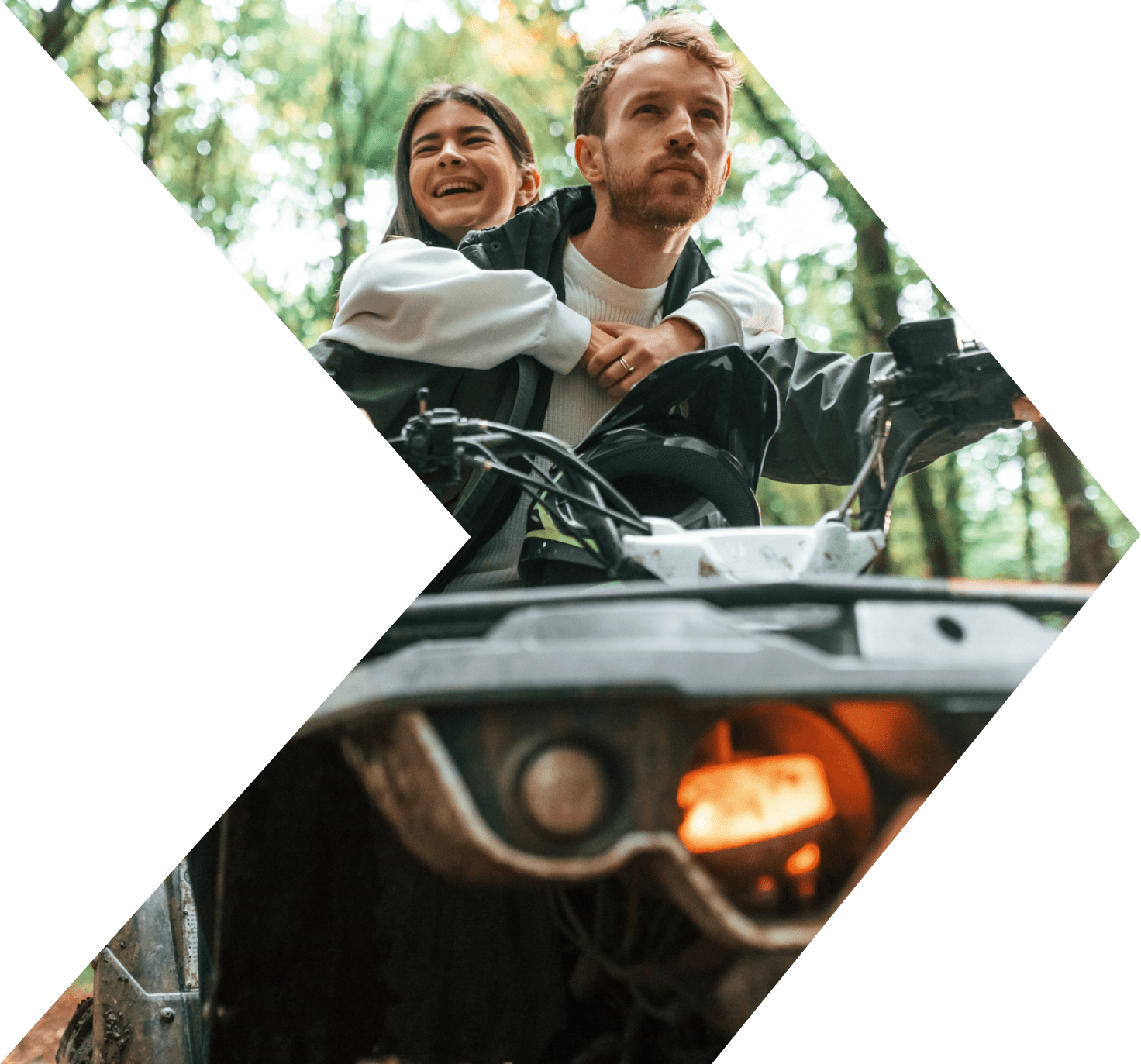 Couple riding ATV through the woods with an ATV Loan from Peach State FCU