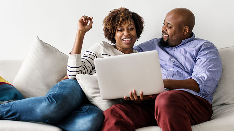 Couple-on-couch-with-laptop-researching mortgage options.