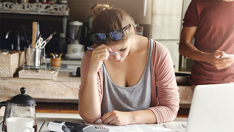 Frustrated-woman-at-desk-after-receiving-bad-credit-loan-and-is-in-worse-debt.