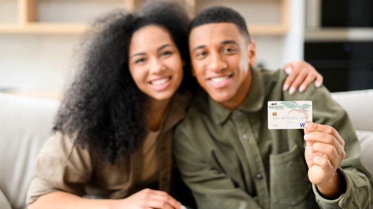 a happy couple holding up their Peach State credit card