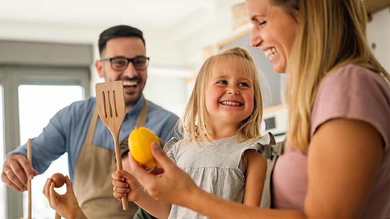 Happy family with children preparing healthy food together in kitchen