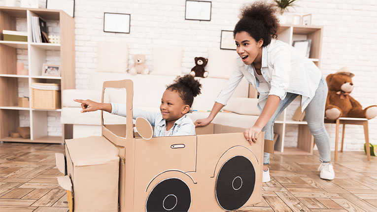 Mom and child celebrating finding an affordable used car by playing in living room together.