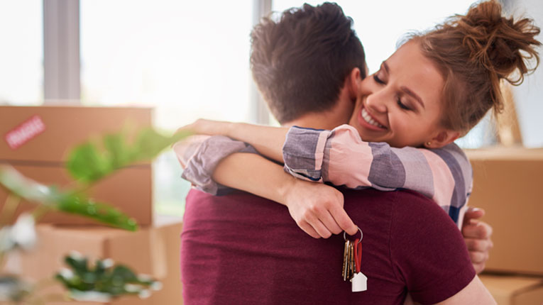 home loans do not have to be complicated couple hugging while holding home keys to new house
