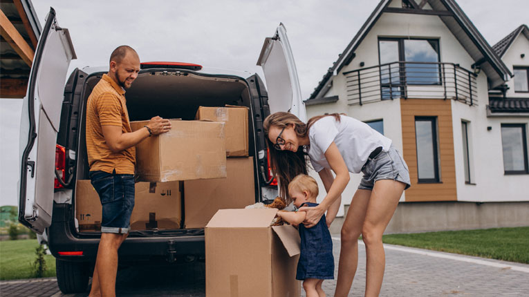 knowing-what-to-look-for-when-buying-a-house-is-critical-family-unpacking-van-in-front-of-new-house