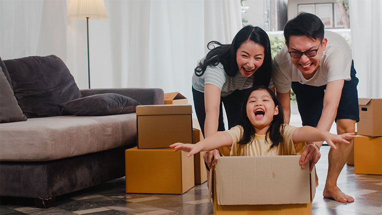 This first time home buyer family is enjoying their new home and playing with their child in the moving boxes.