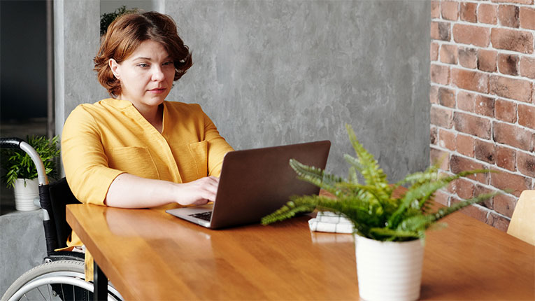 Woman in wheelchair researching the best mortgage lenders in her area.