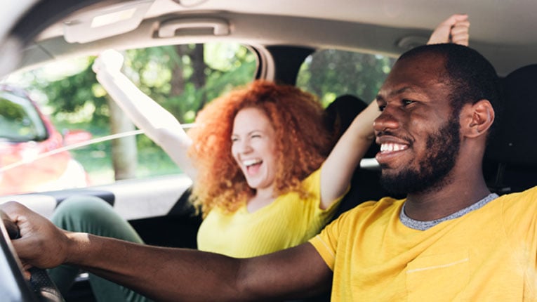 Young-couple-discovered-the-best-credit union-in-Georgia-for Car-Loans-is-Peach-State-as-they-drive-away-in-a-new-car.