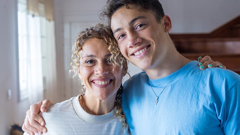 grateful teenager man hug smiling middle-aged mother show love and care